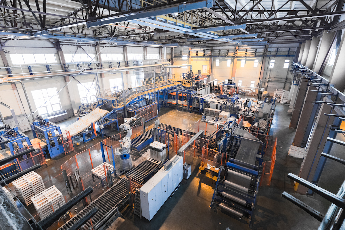 Factory workshop interior and machines on glass production background